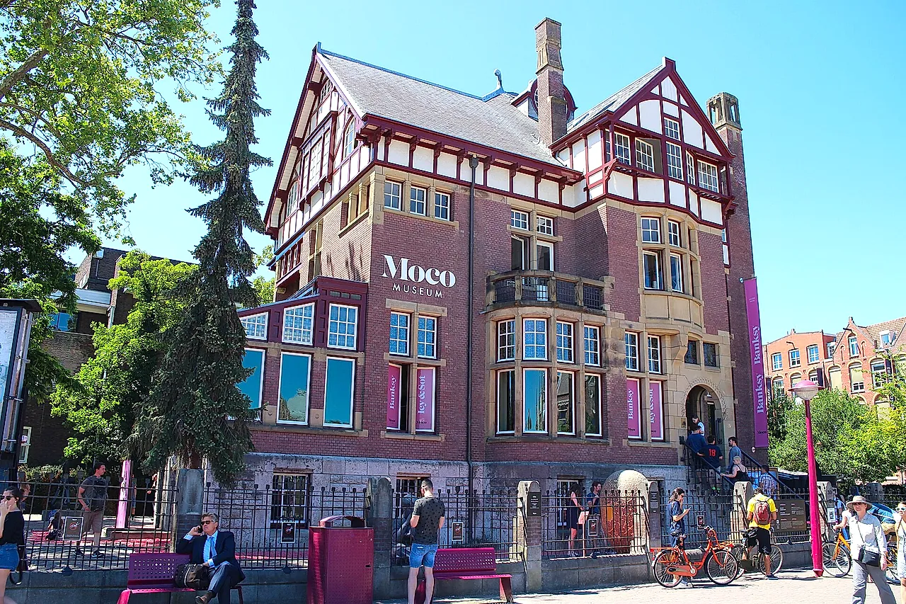 The Moco Museum villa seen from the street, with the Moco sign on its front, half-timbered gables and large windows